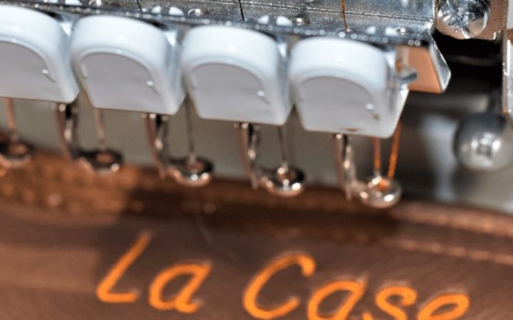 Brodeuse professionnelle brodant un logo sur un set de table en simili-cuir