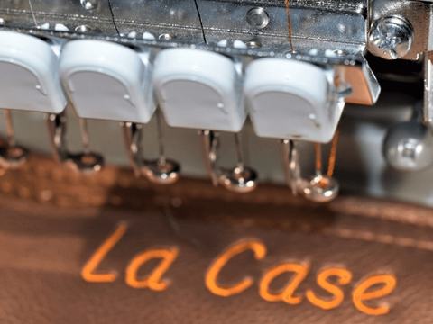 Brodeuse professionnelle brodant un logo sur un set de table en simili-cuir